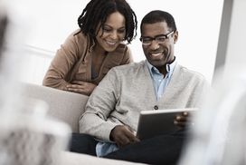 一对夫妇,男人和女人坐在共享数字平板电脑。