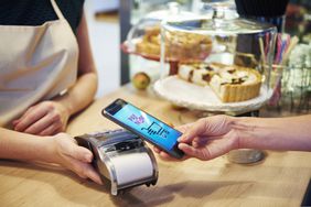 顾客在咖啡馆用智能手机无现金支付