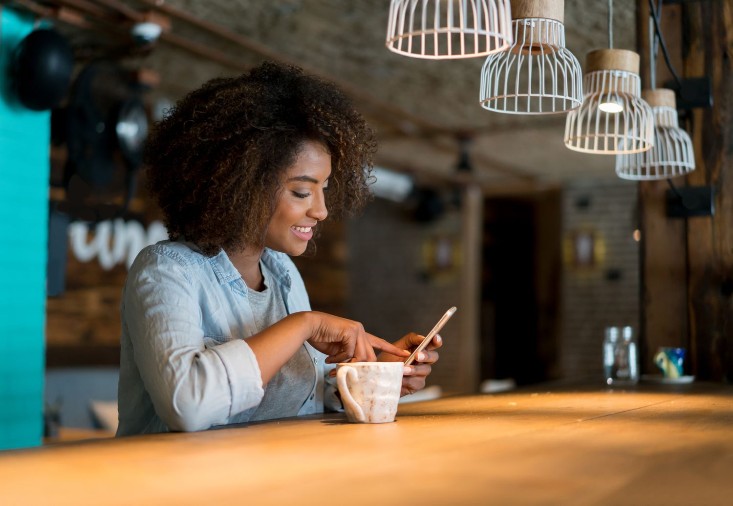 一个人在咖啡馆边喝咖啡边用手机看社交媒体