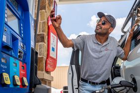 Guy Benhamou sends a picture of gas prices to friends while pumping gas at an Exxon Mobil gas station on June 09, 2022 in Houston, Texas.