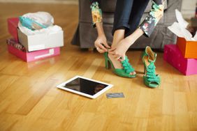 女人用平板电脑和信用卡试穿绿色高跟鞋