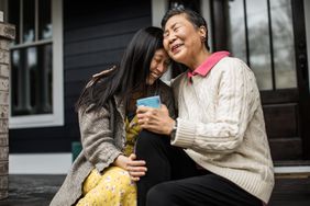 父母和成年子女在前廊拥抱。