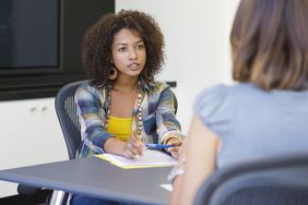 women talking across office table