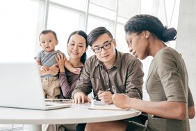 Young couple with toddler sitting at a desk with accountant