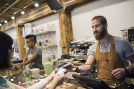 客户用信用卡支付咖啡师在咖啡馆