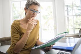 成熟的女人审查退休计划的文书工作