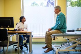 女医生在诊所与年迈的病人交谈