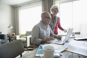 一对老夫妻一起用笔记本电脑工作。