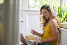 微笑的女人在笔记本电脑上输入信用卡信息
