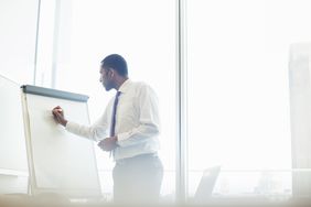 Businessperson writing on whiteboard