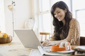 Smiling woman using laptop at table