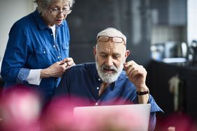 老年夫妇在接受生活成本调整(COLA)后查看他们的退休收入。＂>
          </noscript>
         </div>
        </div>
       </div>
       <div class=