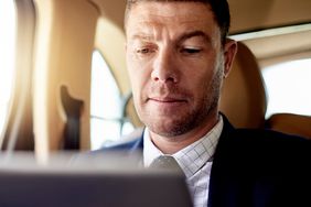 一个商人用平板电脑检查他的投资。