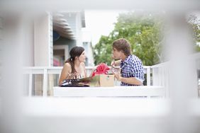 一对年轻夫妇在阳台的桌子上为经济问题争吵