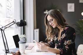 A woman sits at a desk with a computer.