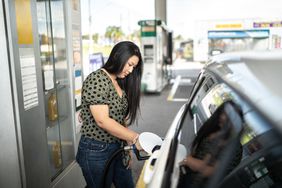 一名女子在加油站给汽车加油