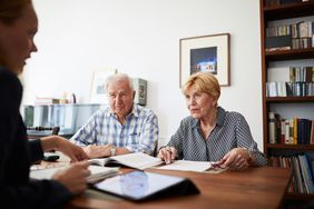 一对老夫妇与信用顾问会面，审查他们的债务减免方案。