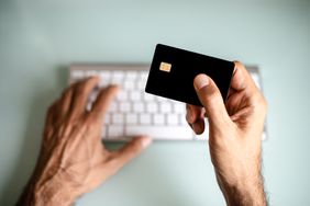 一个男人用信用卡，网上购物，电子银行