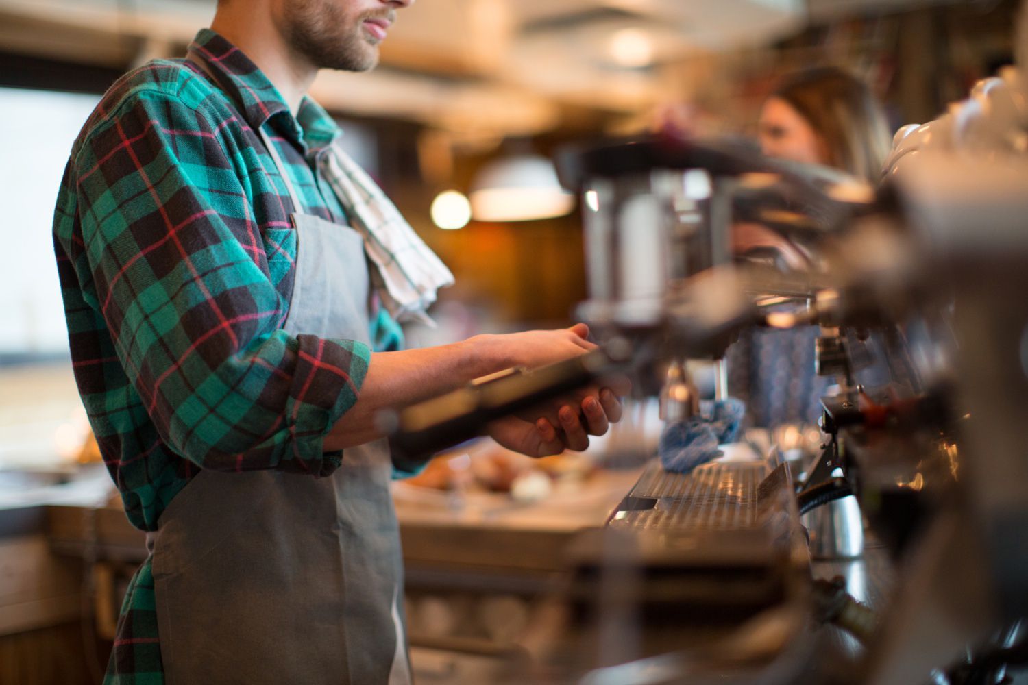 在一家顾客经常进行小额交易的咖啡店工作的咖啡师
