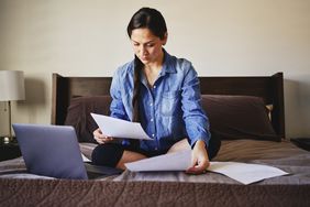 Woman sitting in bed working.