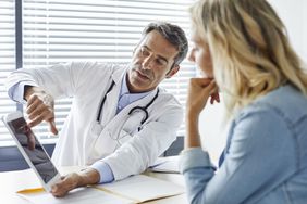 Doctor showing health information to patient