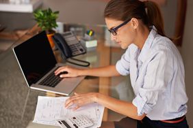 女人从事个人预算在一台笔记本电脑。