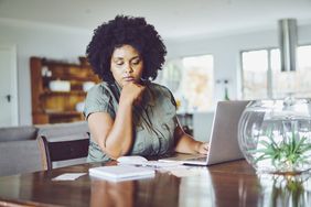 女人在家里付账单时看起来很担心。