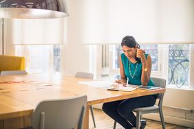 会议桌上的女人拿着杯子审查文件