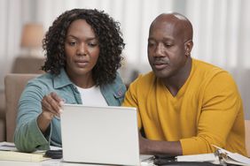 A couple looks at a laptop