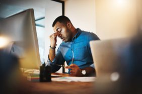 Shot of a young businessman experiencing stress during a late night at work