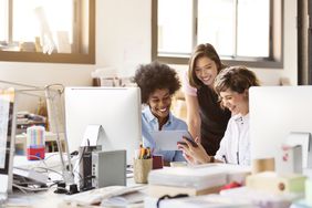 快乐的商业女性在办公室使用数字平板电脑