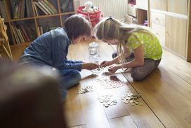 两个孩子一起在地上数硬币＂width=