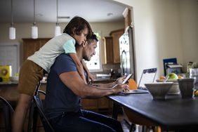 男人在家里用笔记本电脑工作，孩子看着＂>
          </noscript>
         </div>
        </div>
       </div>
       <div class=