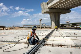 德克萨斯州RVING - 8月10日:2022年8月10日，德克萨斯州欧文市，一名焊工在前达拉斯牛仔体育场欧文立交基础设施项目的立交桥上工作。这项耗资3.01亿美元的项目于2020年启动，将于2023年结束，包括重建SH 183、SH 114、12号环路和482号马刺交汇处。德克萨斯州运输部表示，欧文项目中32座4.8英里的桥梁和4.6英里的道路将使用26.1万平方英尺的混凝土，这是德克萨斯州“畅通车道”倡议的一部分，旨在减少德克萨斯州城市地区的拥堵。达拉斯牛仔队在德克萨斯州欧文市的德克萨斯体育场比赛了38个赛季。2010年，随着NFL球队搬到德克萨斯州阿灵顿附近的AT&T体育场，该建筑在一次可控内爆中被拆除。