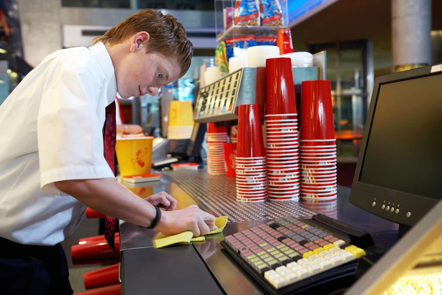 少年(14-16岁)在电影院清洁茶点柜台