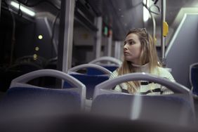 年轻女子骑回家巴士在塞浦路斯