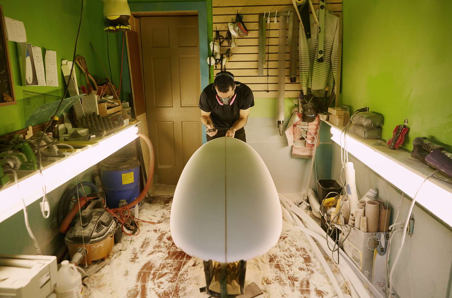 缅因州一家冲浪用品店，一名塑形工正在制作冲浪板＂class=