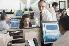 Professional traders looking at screens in a trading room