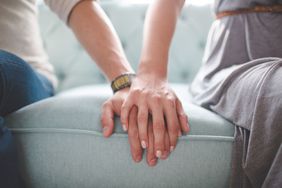 一对夫妇在治疗师的沙发上手牵着手。