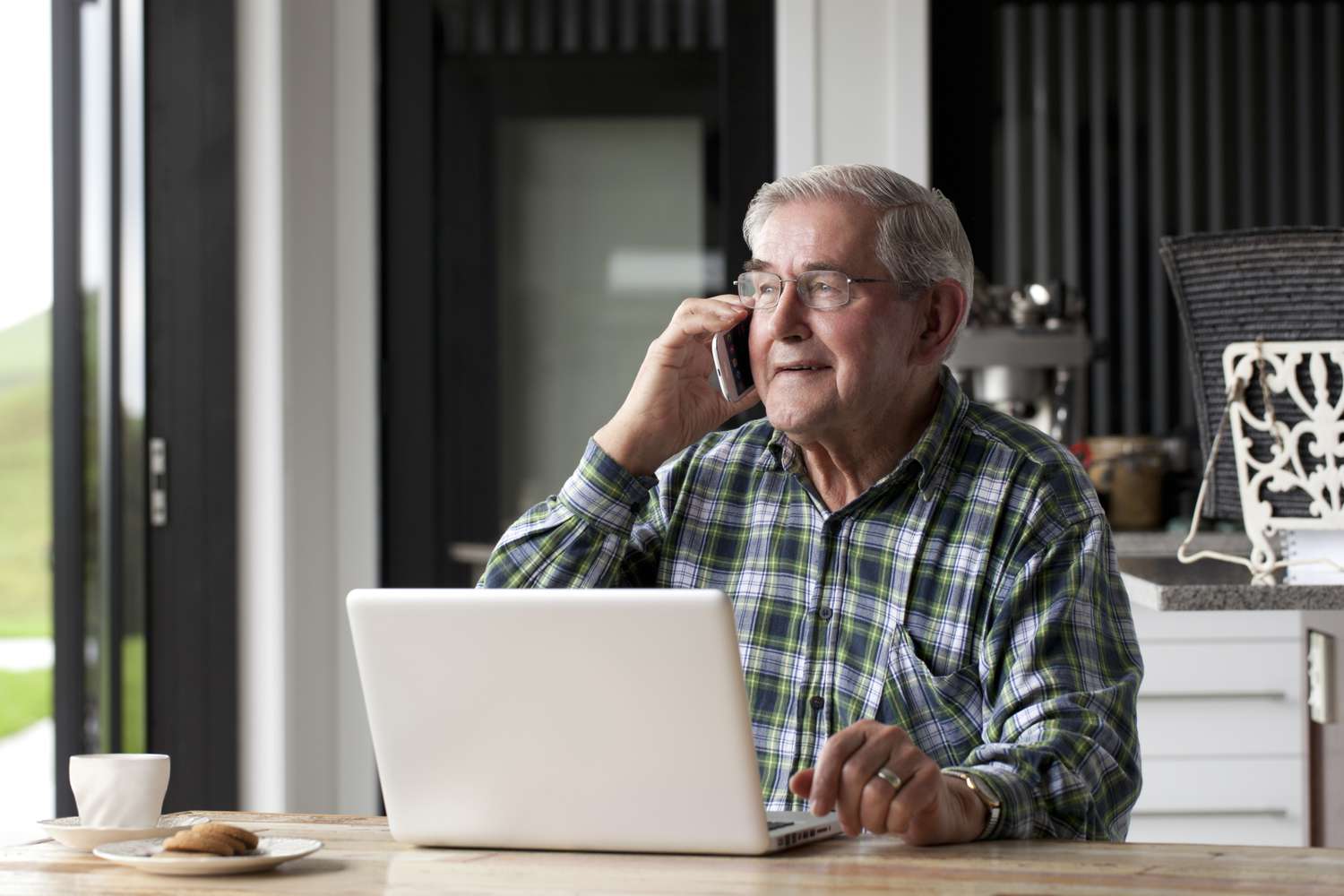 老人用笔记本电脑和智能手机说话