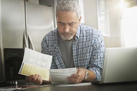 A person reviews paperwork in a clean, well-lighted kitchen.