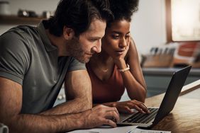一对年轻夫妇在笔记本电脑上审查他们的投资。