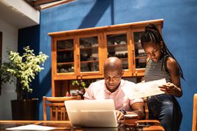 Parent and teen working on laptop at home