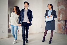 Real estate agent showing a home to a young couple