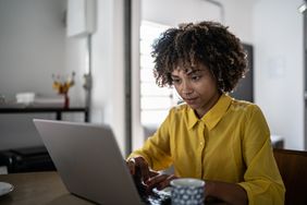 年轻女子使用笔记本电脑在家工作