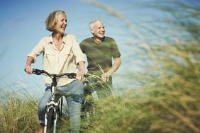 一对老夫妇骑着自行车穿过一片田野。
