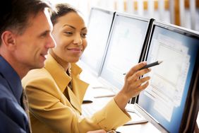 专业的男人和女人在电脑工作站观察股票走势