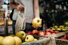 一名妇女在农产品市场选购苹果。