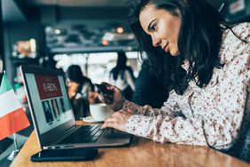 网上购物的女人在咖啡馆在笔记本电脑上