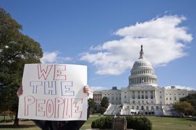 一个人在美国国会大厦前举着标语牌